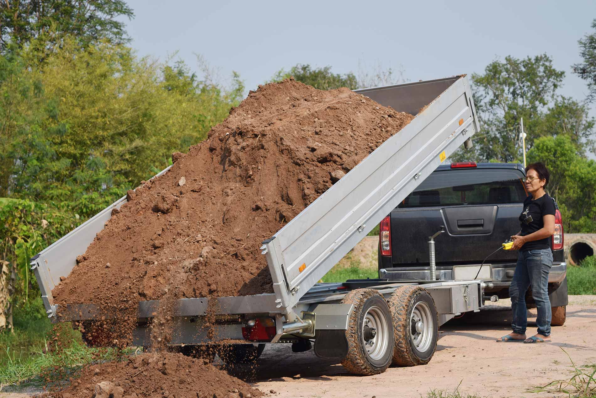 Heavy-duty dump trailers loaded with various landscaping materials.